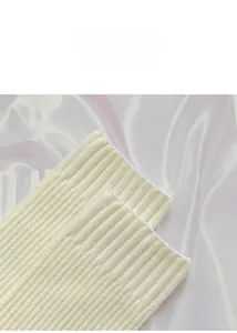 Macro detail of the ribbed cuff texture on a cream-colored thick cashmere-like sock