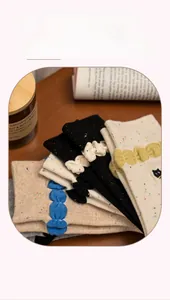 Detail of vintage knit crew socks with colorful dots and ruffled cuffs on wood surface