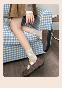 Close-up of cute rabbit socks paired with plush brown Mary Jane shoes and socks