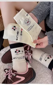 Close-up of white mid-calf socks with cute cartoon dog pattern and rib-knit cuffs