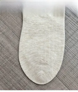 Macro detail of breathable knitted wool sock toe in beige featuring seamless comfort design