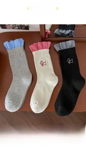 Detail of cotton crew socks with puppy embroidery and plaid ruffle trim in three colors