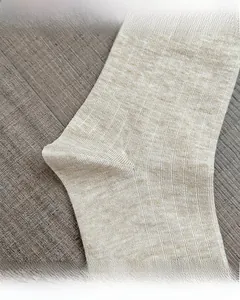 Close-up of beige knit wool socks showing reinforced toe and heel stitching detail