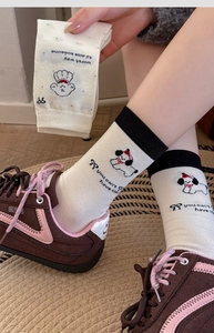 Detail of knit socks featuring cute cartoon dog patterns and English text graphics