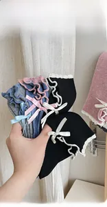 Close-up of knit cotton socks with bow accents and ruffled cuffs in assorted colors