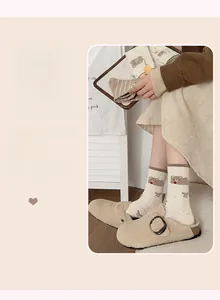 Detail von beigen Socken mit niedlicher Bärenstickerei und weichem Kräuselsaum