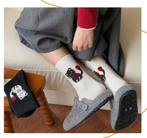 Detail von süßen Katzenmuster Socken und warmen Plüschhausschuhen in Wohnambiente