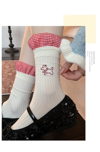 Detail of white cotton socks with cute puppy embroidery and red gingham lace trim edges