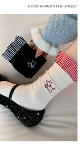 Detail of embroidered puppy on mid-calf socks with ruffled plaid cuffs in combed cotton