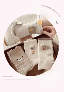 Nahaufnahme süßer Bärenmuster auf atmungsaktiven Baumwollsocken in warmen Erdtönen