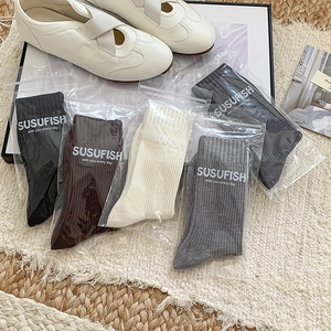 Set of five ribbed knit mid-calf cashmere socks in neutral colors with casual shoes