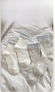 Detailed close-up of blue-grey striped cotton mid-calf socks with decorative buttons