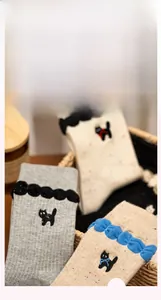Macro view of cute cat embroidery and delicate lace trim on cotton crew socks