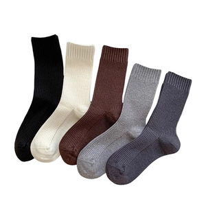 Five pairs of ribbed cashmere-feel socks in neutral tones like black, beige, and grey