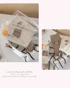 Detailansicht der Bärenstickerei auf Baumwollsocken mit Reißverschlussverpackung