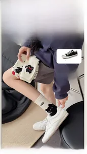 Detailed view of off-white mid-tube cotton socks with black cat pattern and miao text