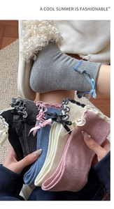 Detail of ruffled lace cuffs and ribbon bows on women cotton mid-calf socks
