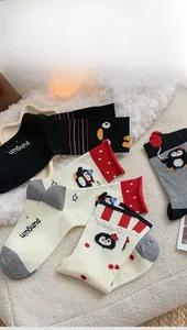 Close-up of cute cartoon penguin socks in black, beige and grey with soft fleece texture