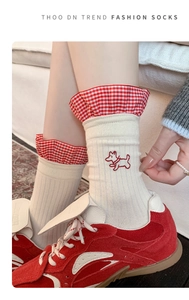 Detail of cream white socks with red plaid ruffle trim and cute dog embroidery
