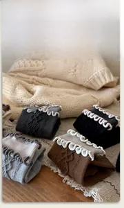 Detailed knit texture of wool socks featuring elegant wavy ruffled edges in various colors
