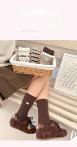 Dettaglio ravvicinato di calze marroni calde con motivi vintage e trame a maglia