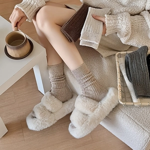 Winter cable knit socks with plush open-toe slippers in a warm home setting