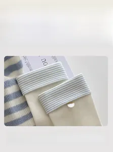 Detailed close-up of elastic striped cotton socks with button decor and rolled cuff