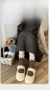 Detail of wool silk socks featuring brown embossed diamond pattern and frilly white trim