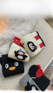Close-up of cozy cotton socks featuring cute cartoon penguin patterns and ribbed cuffs
