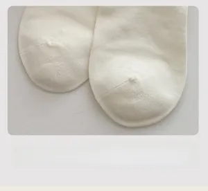 Close-up of flat seamless toe stitching on premium white knitted crew socks for women