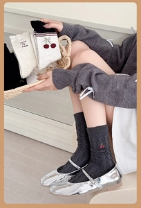 Detail of wool socks featuring cherry embroidery and stylish knit texture