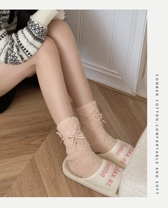 Detailansicht der Korallenvlies-Socken mit Schleifen und gemütlichen Hausschuhen