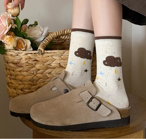 Detail of khaki suede clogs paired with cloud pattern crew socks and star prints