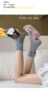 Detail of sweet bow-knot rib-knit socks with ruffled edges in grey, beige, and pink colors
