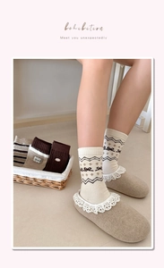 Dettaglio di calze in maglia Fair Isle con motivi jacquard geometrici e fiocco decorativo