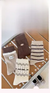 Dettaglio di quattro paia di calze in maglia Fair Isle vintage nei toni marrone e beige