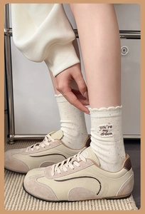Detail of cream knit socks with 'you're my dream' embroidery and scalloped edges