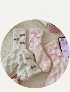 Detail of coral fleece socks featuring plush texture and decorative plaid bows