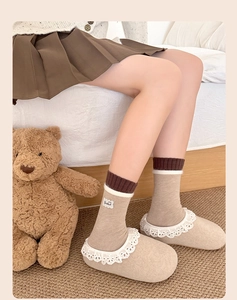 Dettaglio di calze in maglia con bordo in peluche e etichetta Goodluck con pantofole accoglienti