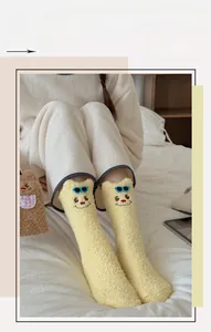 Close-up of yellow fleece socks with cute 3D cartoon smiley face and blue sunglasses