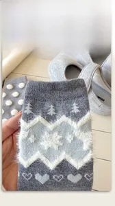 Detail of grey winter knit socks with festive snowflake patterns and plush jacquard texture
