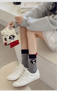 Close-up of cute cartoon penguin embroidery on cotton crew socks with ribbed cuffs