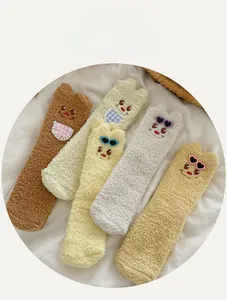 Close-up of five colorful coral fleece socks with cute 3D cartoon bear ears and soft texture