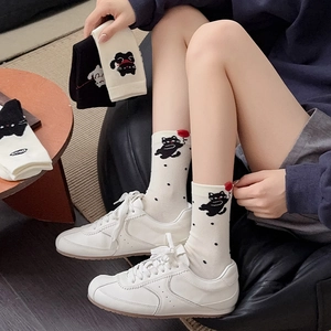 Cute white crew socks with black polka dots and cartoon cat pattern with sneakers