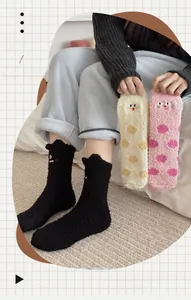Detail of soft coral fleece socks with cat embroidery and warm polka dot patterns