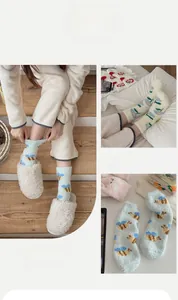 Détail de chaussettes d'hiver en polaire corail avec broderies d'animaux et texture douce