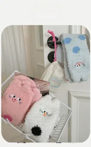 Detail of coral fleece socks with cat embroidery in pink, white, and blue colors