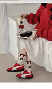 Detail of red and white striped crew socks with cute cartoon animal flocking patterns