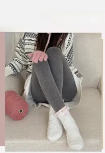Dettaglio calzini in pile corallo bianco con bordo in pizzo e fiocchi rosa a quadretti