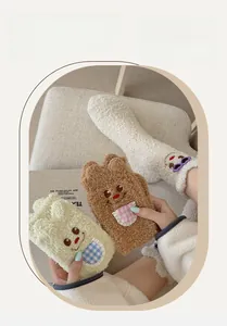 Detail of cute embroidered bear faces and plush 3D ears on warm coral fleece socks